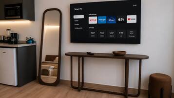 A modern living room with a flat-screen TV mounted on the wall displaying a smart TV interface.
