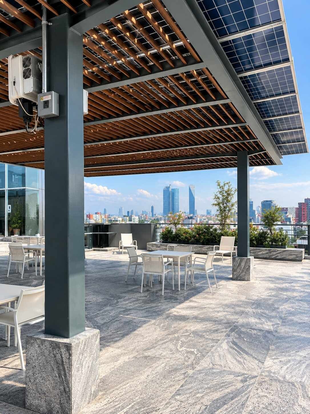 An outdoor seating area with tables and chairs, a pergola with solar panels, and a city skyline in the background.
