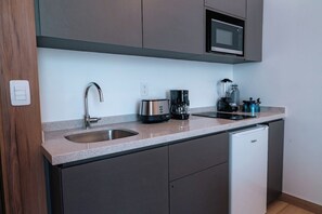 A compact kitchen with a sink, a coffee maker, a blender, and a microwave. - Condesa Residence - Roma Luxury Suite 606 (Mexico City)