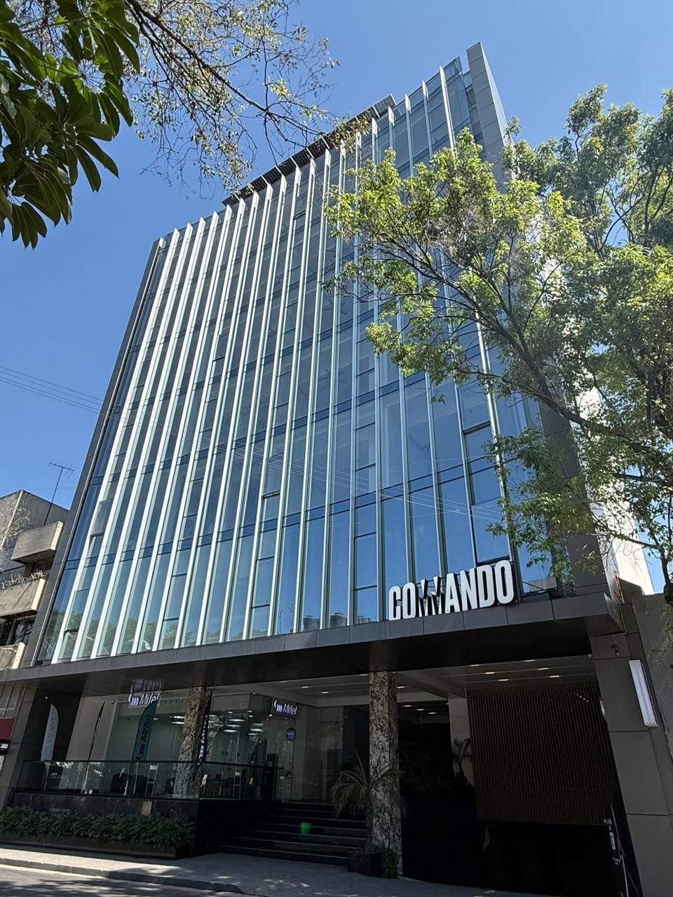 A modern building with a glass facade and the name 'COMANDO' prominently displayed.