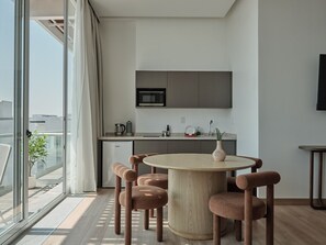 A modern kitchen with a round dining table and six chairs, a microwave, and a sink. - Condesa Residence - Roma Luxury Suite  305 (Ciudad de México)