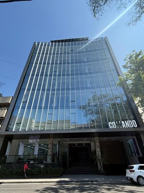 A modern building with a glass facade and the name 'GOMANDO' on the ground floor. - Condesa Residence - Roma Luxury Suite 403 (Ciudad de México)