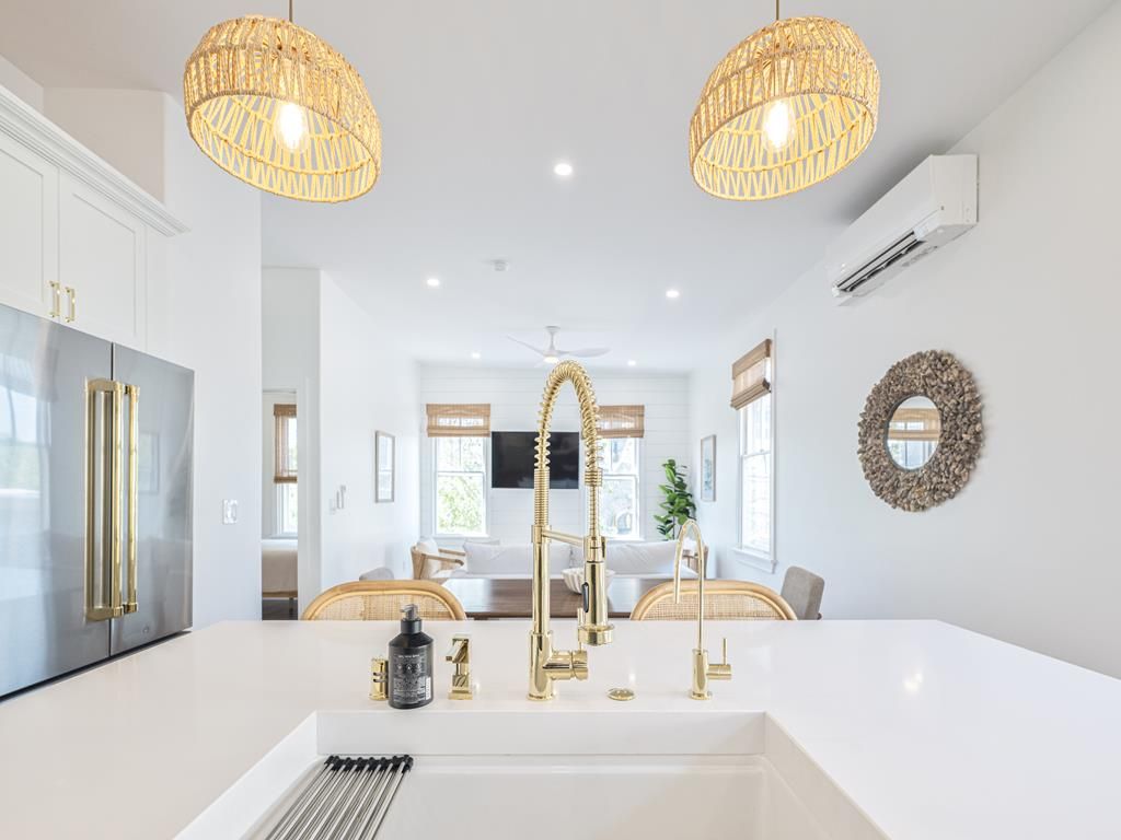 Sleek kitchen with a spacious island and elegant gold fixtures, perfect for entertaining and casual dining.