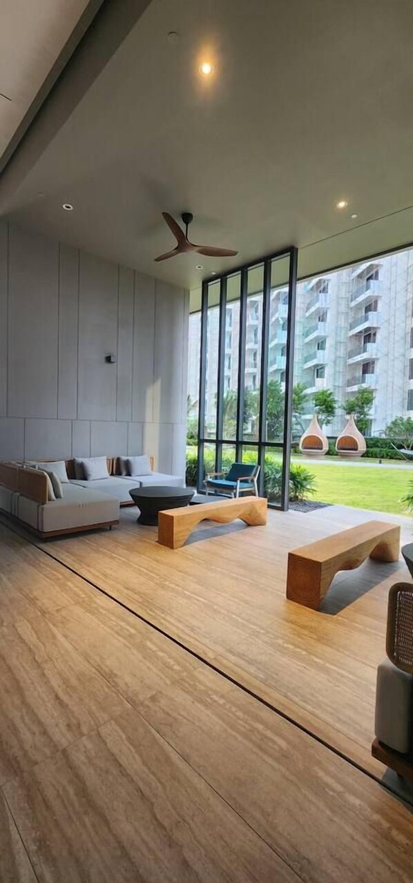 A modern living room with a sofa set, wooden coffee table, and a ceiling fan.