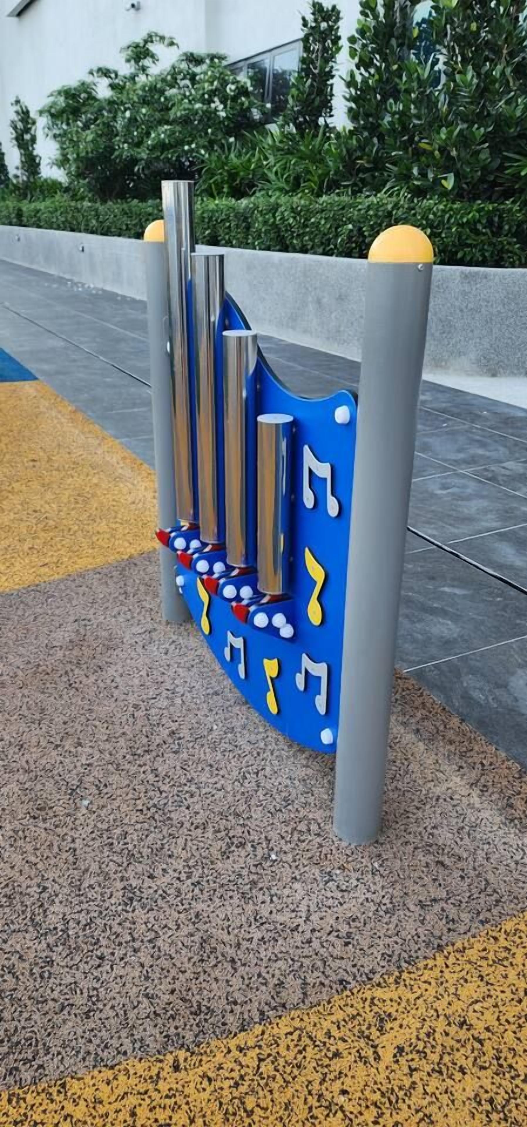 Estructura de juegos con una combinación de colores azul y gris, que incluye un tobogán y notas musicales.