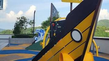 A playground with a slide and climbing structures.