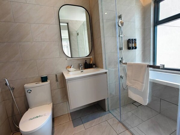 A modern bathroom with a toilet, sink, and shower area.