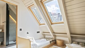 A sloped ceiling room with skylights, a bed with a pillow, and a small wicker basket. - Luderna - Dúplex Val de Ruda C42 eth Pletiu (Baqueira)