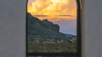 A window view of a mountainous landscape with a clear sky.