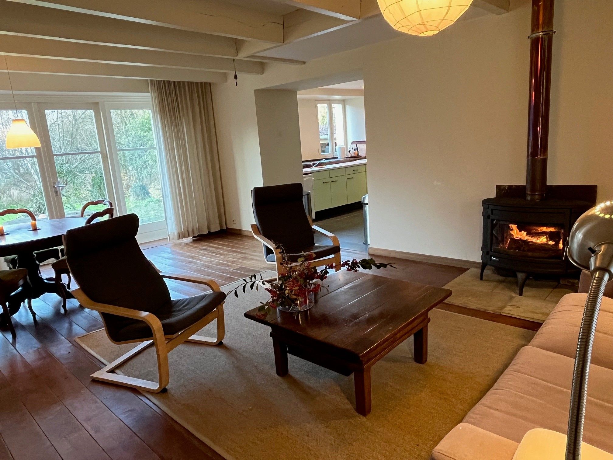 Un salon comprenant un canapé, deux fauteuils, une table basse et une cheminée.