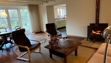 Un salon comprenant un canapé, deux fauteuils, une table basse et une cheminée.
