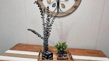A wooden dining table with a decorative wall piece above it.