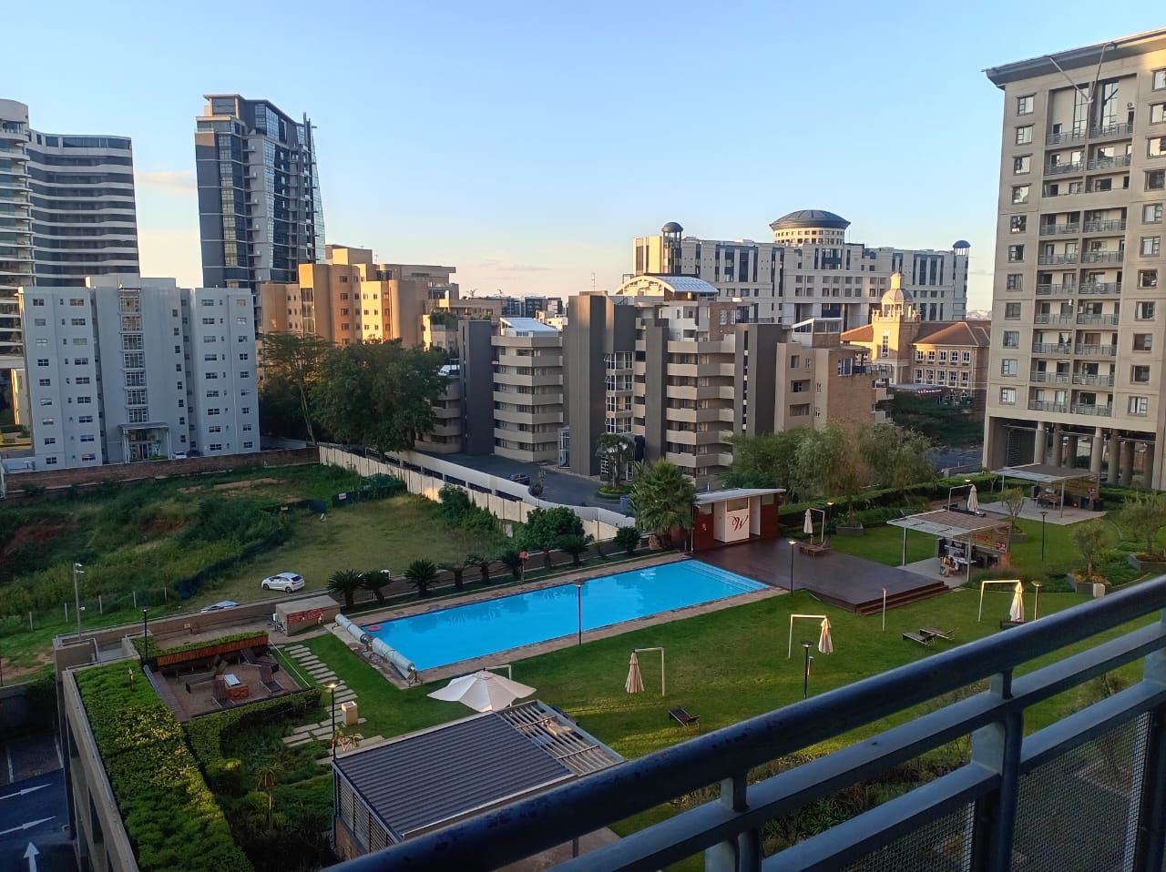 Zona residencial con piscina, varios edificios de apartamentos y un parque pequeño.