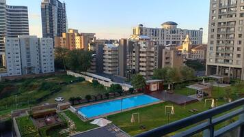 Zona residencial con piscina, varios edificios de apartamentos y un parque pequeño.
