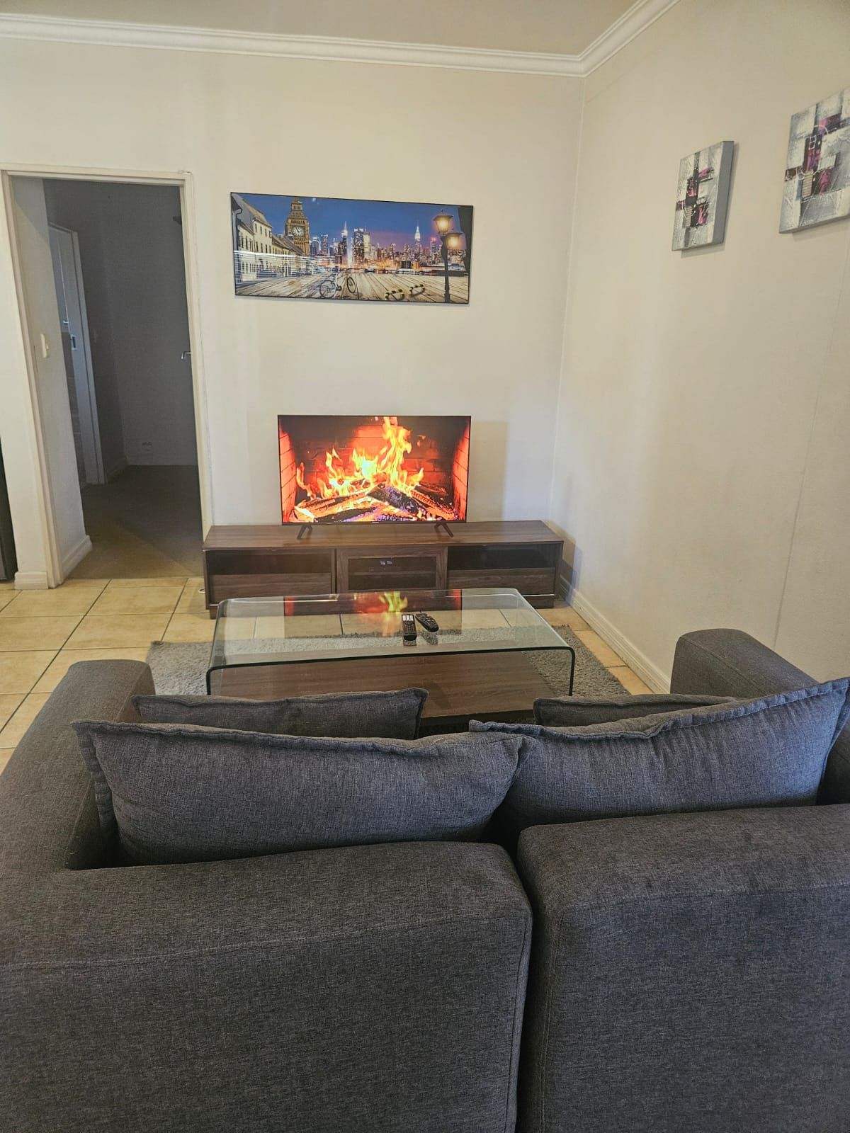 Una sala de estar con chimenea, un sofá y un cuadro en la pared.