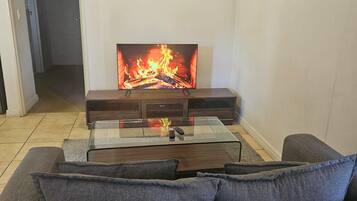 Una sala de estar con chimenea, un sofá y un cuadro en la pared.