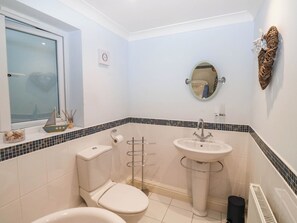 A bathroom with a toilet, sink, and window. - 2 Inglewood Apartments (Dartmouth)