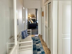 A narrow hallway with a staircase leading to a bedroom. The room has a bed, a nightstand, and a lamp. - Holiday Apartment With 1 Bedroom (Wyk auf Foehr)