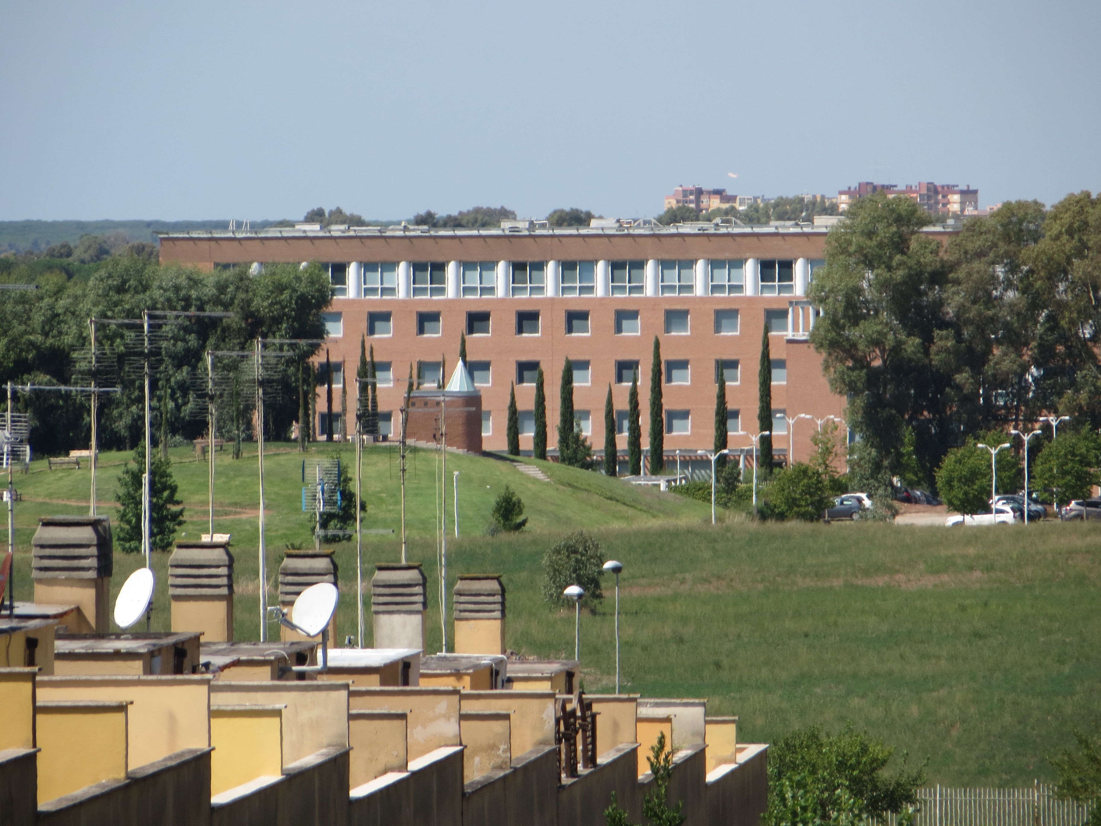 Un bâtiment doté d’un toit plat, de nombreuses fenêtres et d’une façade en briques.