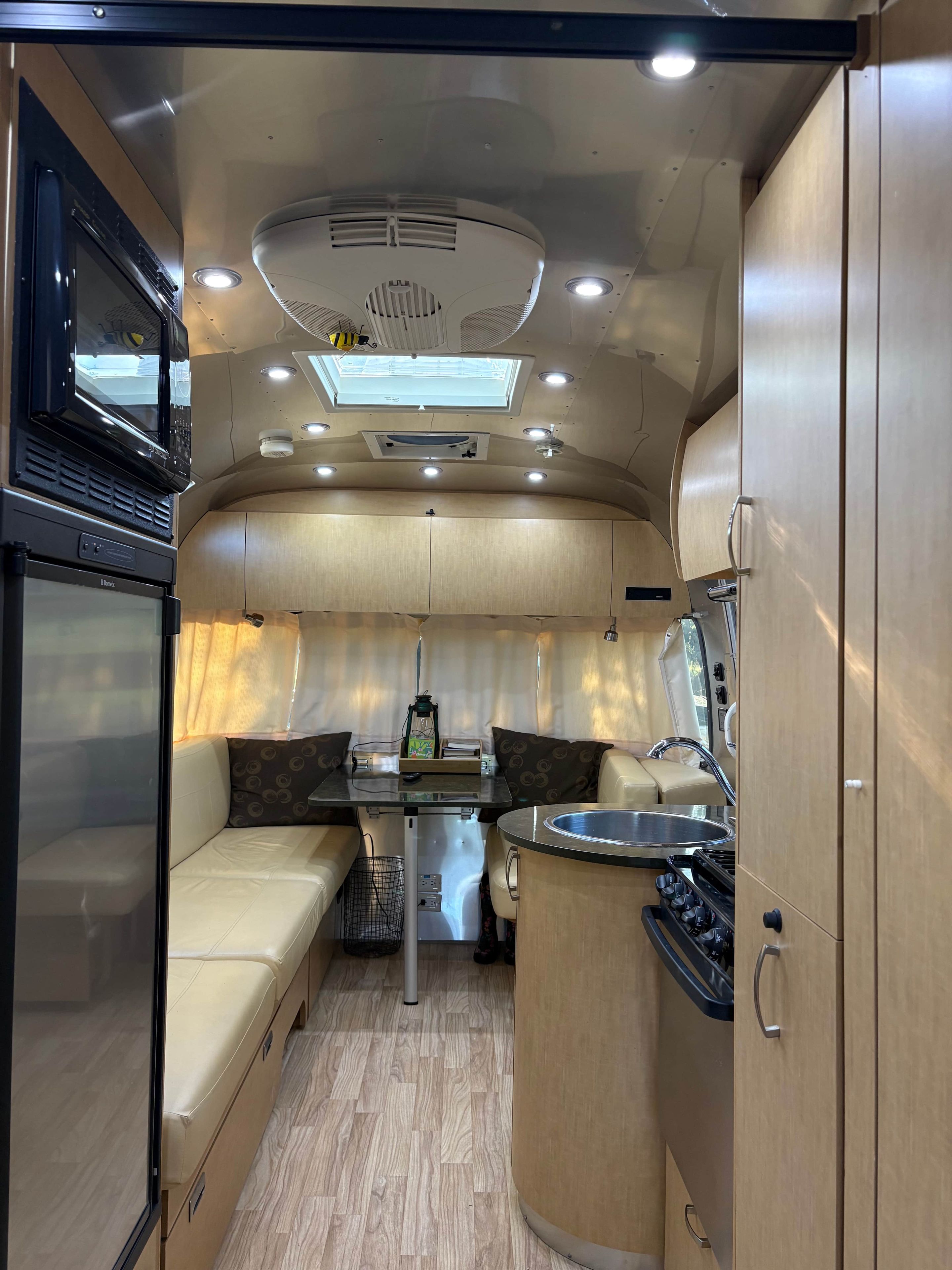 A compact kitchenette with a stove, sink, and a small dining area with a table and seating.