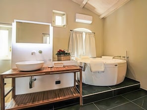 Un bagno con un mobile bagno in legno, uno specchio grande, un lavabo bianco, una vasca e uno spazio doccia.