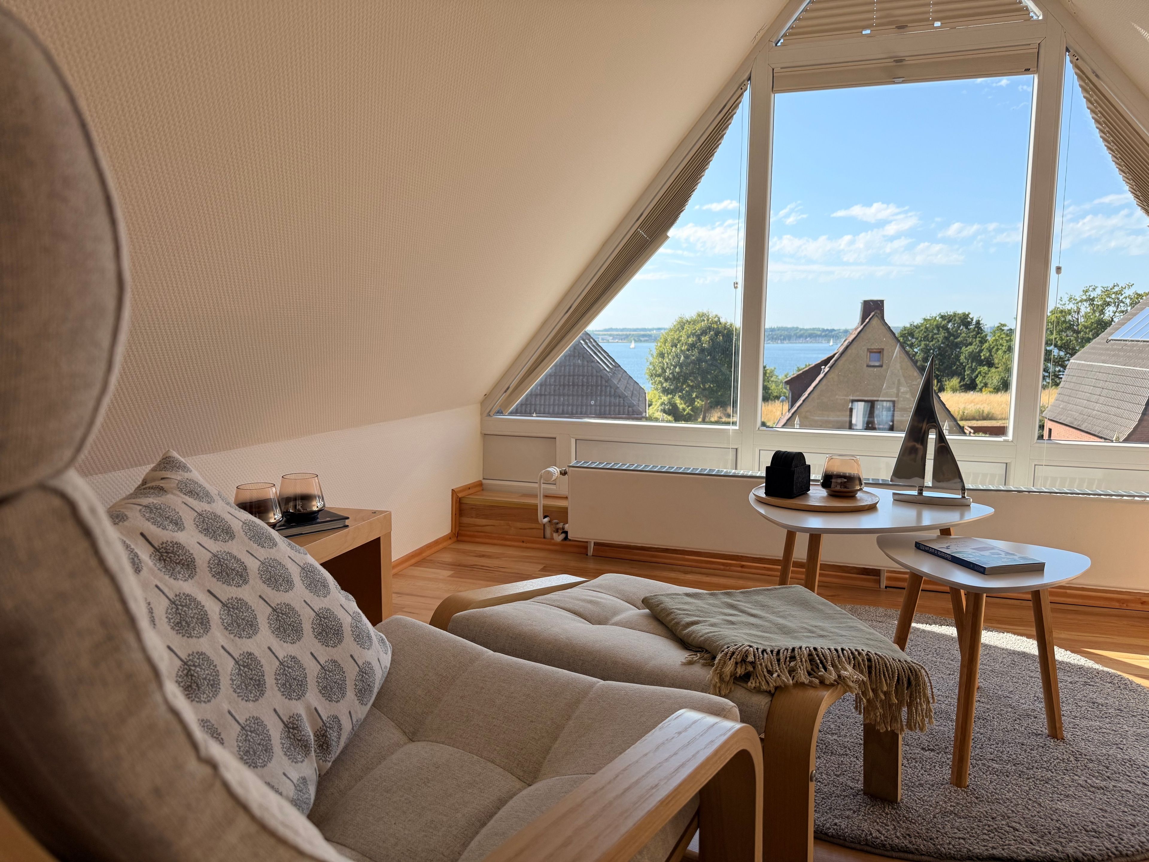 Una habitación acogedora con sofá, una mesita y vista al mar a través de amplios ventanales.