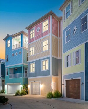 Una fila di edifici residenziali a più piani, con garage privati e cielo sereno.
