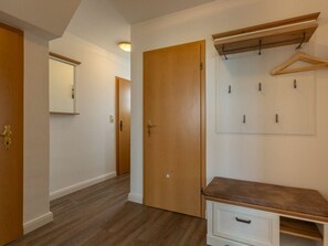 A hallway with wooden doors, a coat rack, and a bench. - Ground Floor on the Left in the Everschop House (St. Peter-Ording)