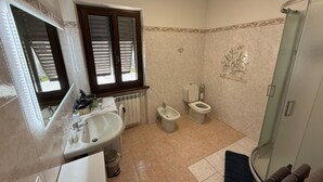 A bathroom with a sink, bidet, toilet, and a glass shower enclosure. - Villa 'Lori' with Mountain View, Wi-Fi and Air Conditioning (Fornaci di Barga)