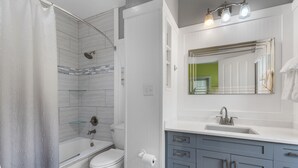 Un baño con ducha, inodoro, lavabo y tocador.