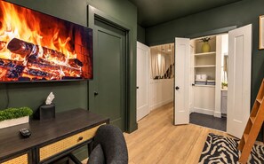 Ein modernes Wohnzimmer mit Kamin, Fernseher und einer gemütlichen Sitzecke.