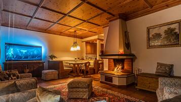 A cozy living room with a fireplace, wooden furniture, and a television.
