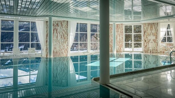A large indoor swimming pool with clear views of snow-covered mountains through large windows. - Villa Bostele with 5 bedrooms (Bad Kleinkirchheim)