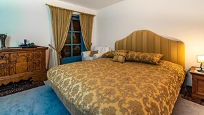 A bedroom with a large bed, a wooden dresser, and a window with curtains. - Villa Bostele with 5 bedrooms (Bad Kleinkirchheim)