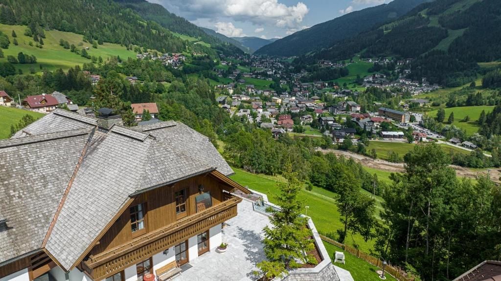 A mountain village with traditional wooden houses and a view of the valley.