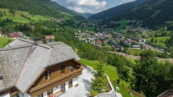 A mountain village with traditional wooden houses and a view of the valley.