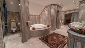 A luxurious bathroom with a marble floor, a freestanding bathtub, and a large mirror. - Villa Bostele with 5 bedrooms (Bad Kleinkirchheim)