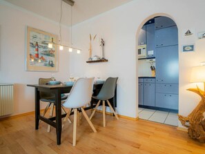 A dining area with a table, chairs, and a kitchen visible through an archway. - 6 in the House at Blanker-hans-weg 5 (St. Peter-Ording)