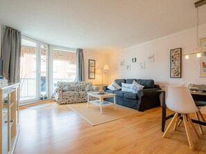 A living room with a sofa, a coffee table, a dining table with chairs, and a lamp. - 6 in the House at Blanker-hans-weg 5 (St. Peter-Ording)