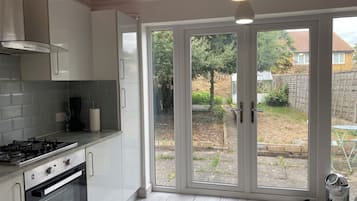 Eine moderne Küche mit Gasherd, Backofen und weißen Schränken.