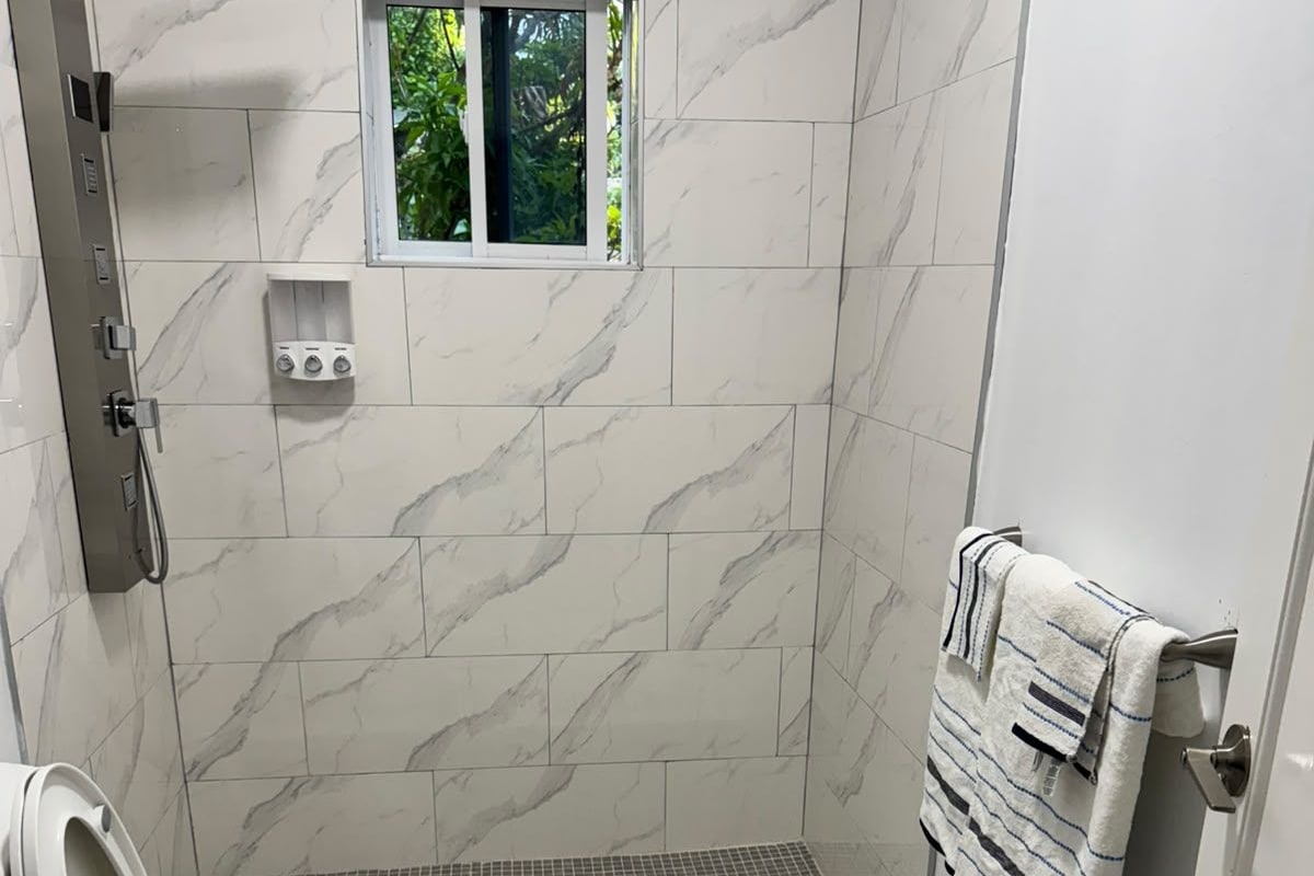 A bathroom with a toilet, bidet, and shower area.