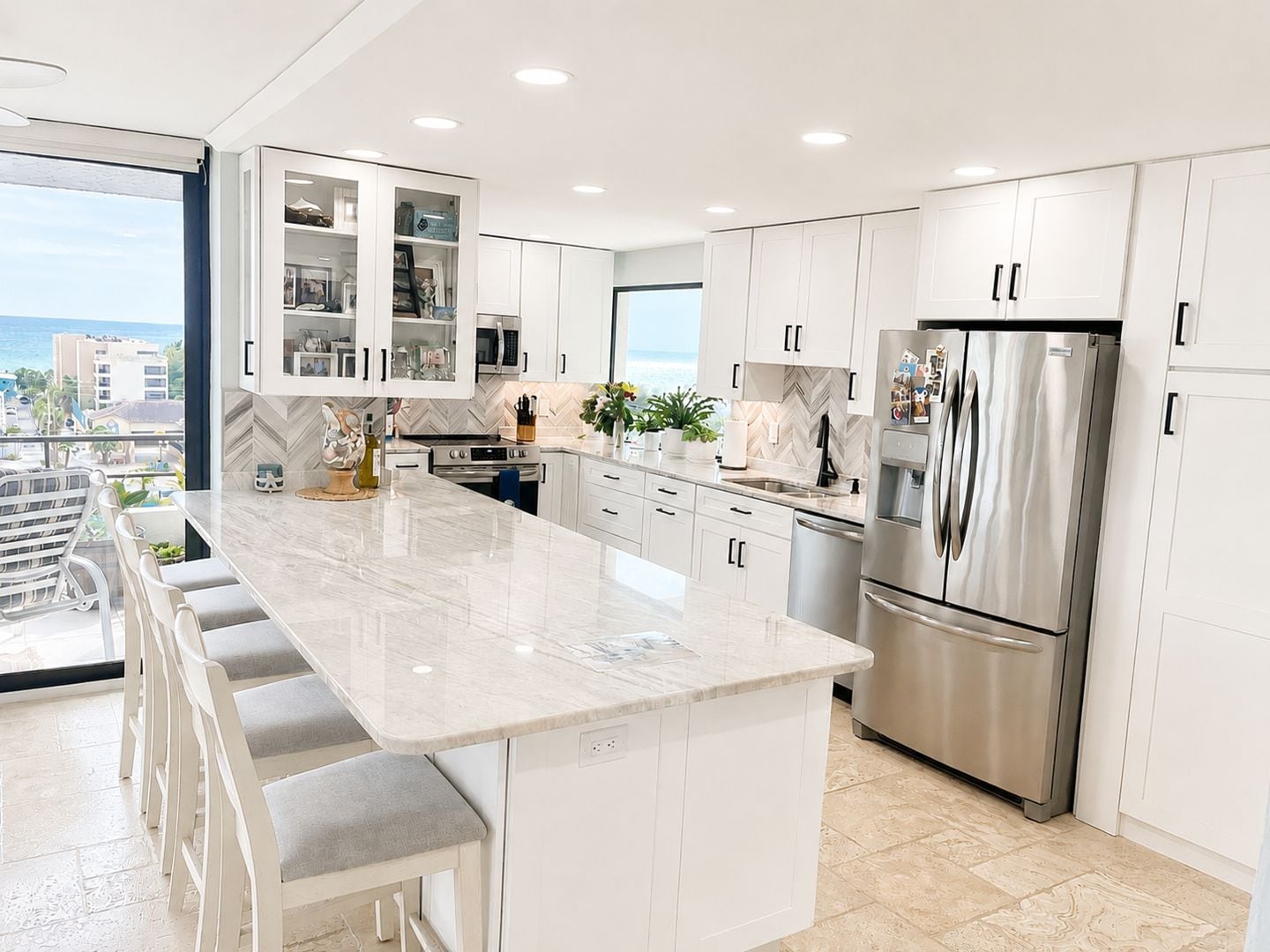 A modern kitchen with a large island, stainless steel appliances, and a view of the city.