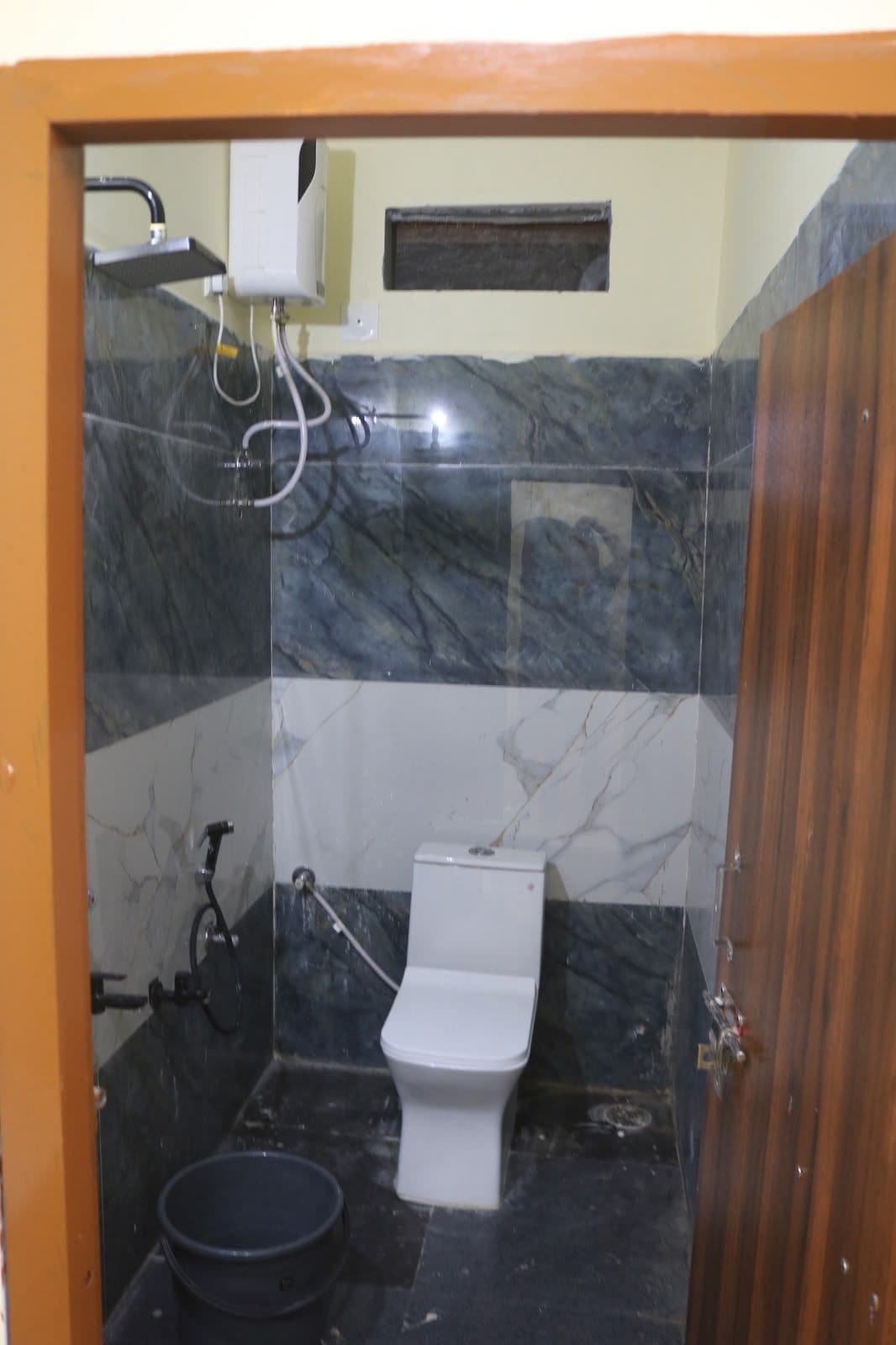 Un baño pequeño con inodoro, ducha y lavamanos.