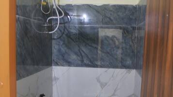Un baño pequeño con inodoro, ducha y lavamanos.