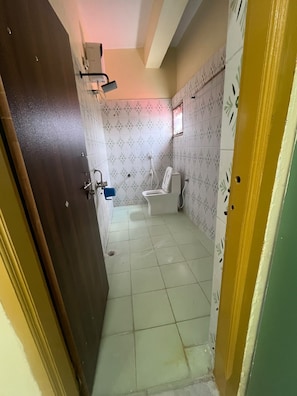 Une salle de bain avec des toilettes, une douche et un lavabo.