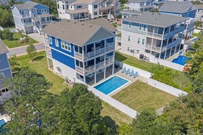 Edifício residencial com vários andares, piscina e área de varanda coberta.