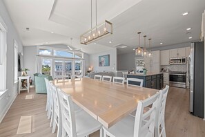 A spacious kitchen with a large island, white cabinetry, and modern appliances. - Corolla Cottage: Semi-Soundfront | Pet Friendly (Corolla)