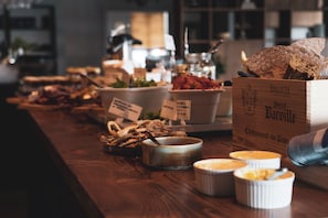 A buffet table with various food items and a wooden box labeled 'Botte Chateauneuf-du-Pape.' - Sörbyn Lodge (Gunnarsbyn)