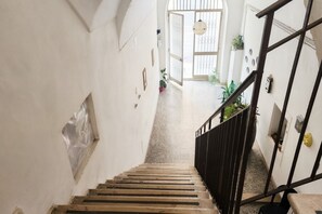 A staircase with a handrail leading to a door with a glass panel. - GuestHost - Central Apartment near train station (Trani)