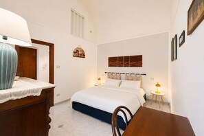 Una camera da letto con un letto, comodini, una cassettiera e un'opera d'arte appesa al muro.